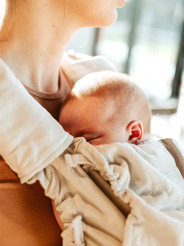 portabebes ergonómico evolutivo de la marca Quokkababy en uso con tres bebés de diferentes edades en el que se aprecia la ergonomía en las diferentes etapas de crecimiento del bebé